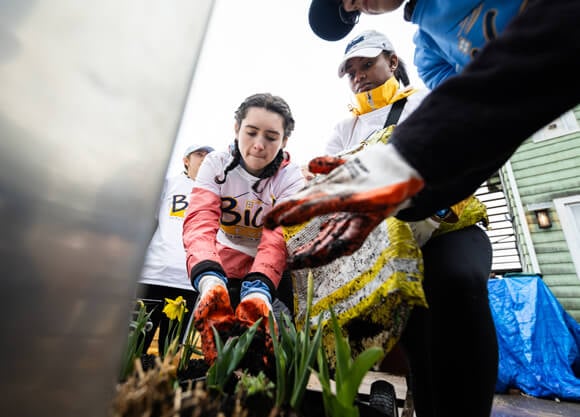 Students work together to plant flowers