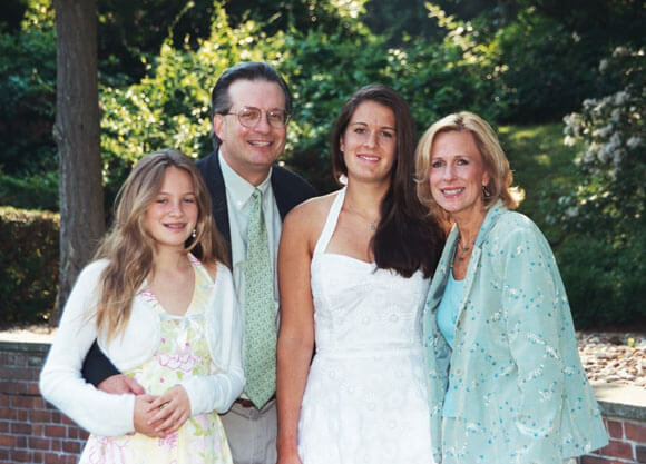 The Petit family smiling in shades of blue and white